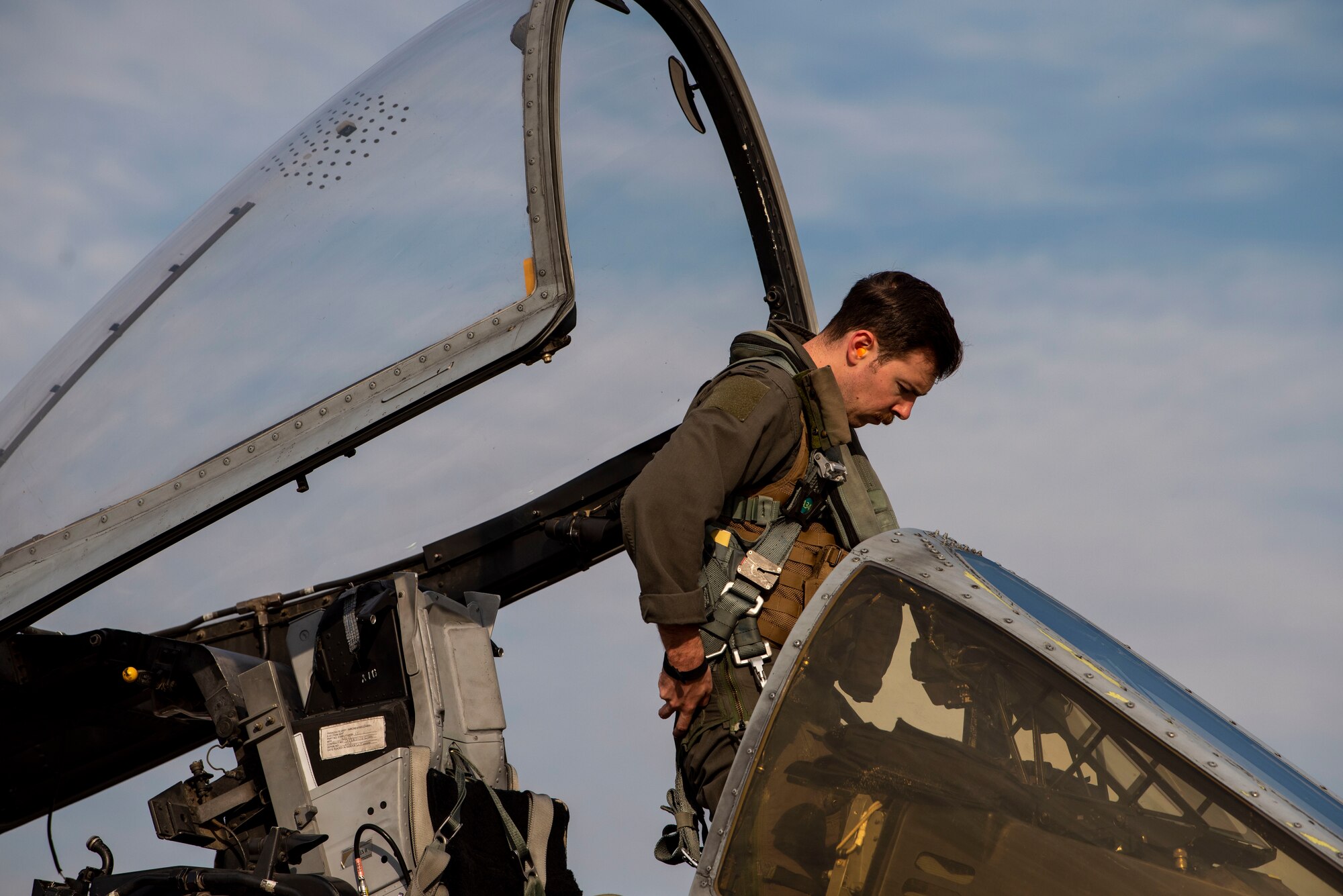 A pilot climbs into the cockpit of an A-10