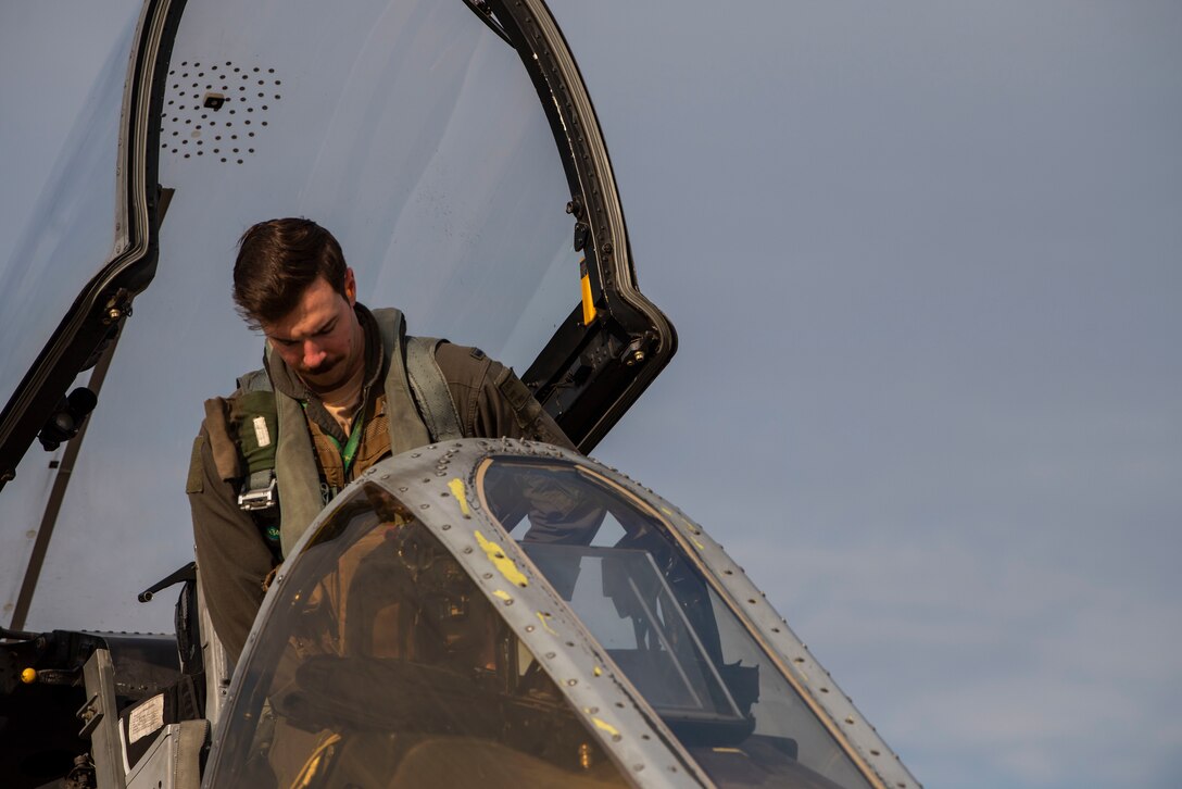 A pilot climbs into the cockpit of an A-10