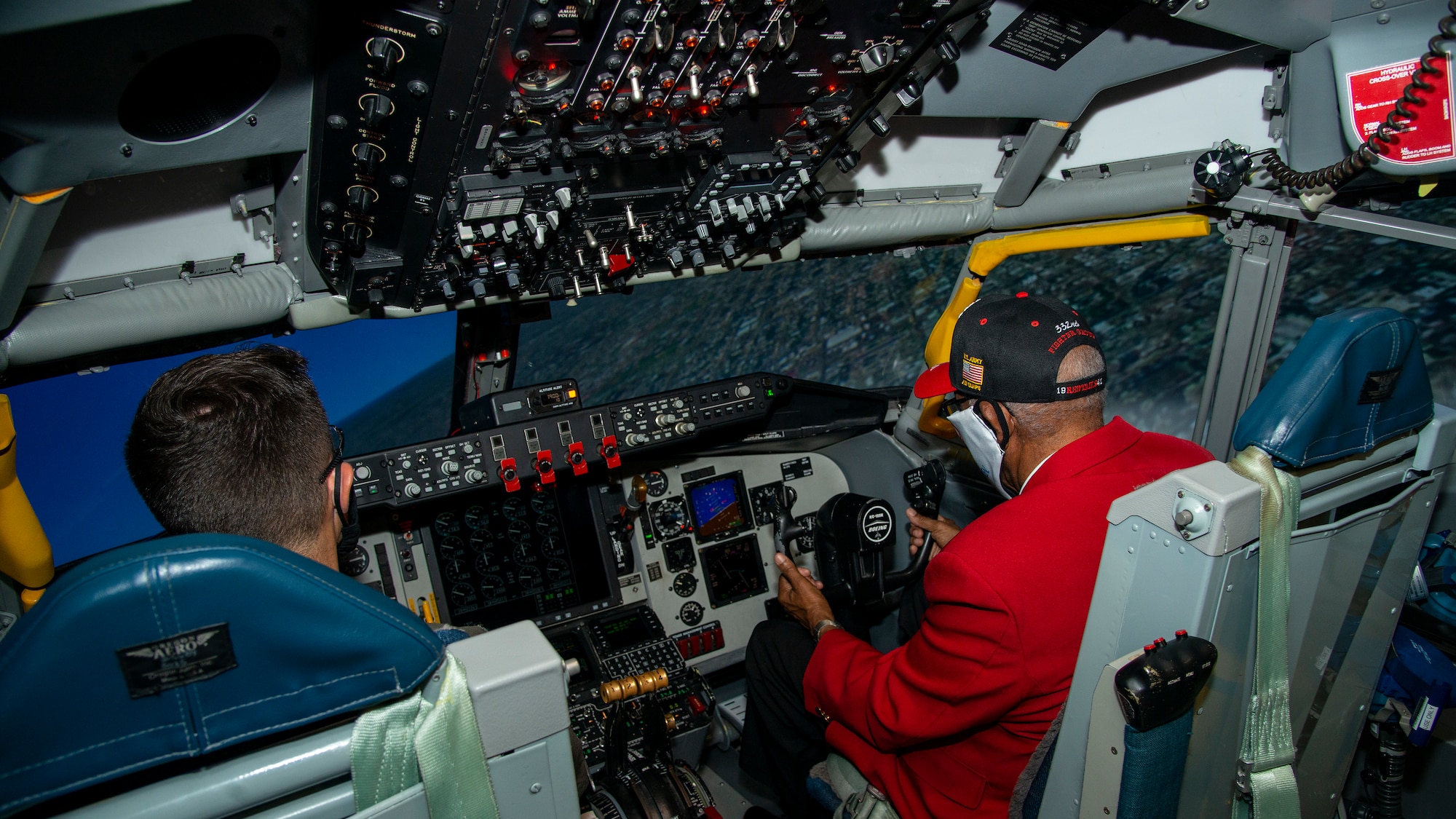 U.S. Army Air Forces Sgt. Thomas Newton, a Documented Original Tuskegee Airman, operators a KC-135 Stratotanker flight simulator with U.S. Air Force Capt. Adam Geeskie, a 50th Air Refueling Squadron pilot, at MacDill Air Force Base, Fla., Nov. 10, 2020.