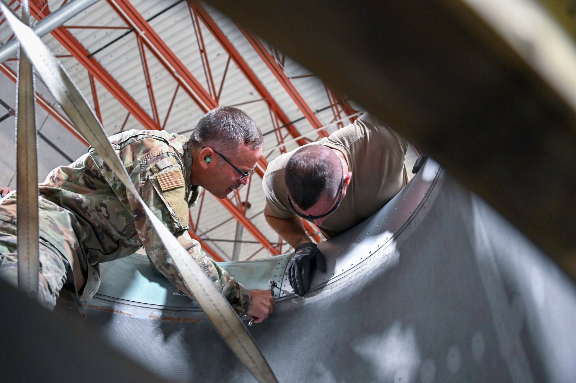 Master Sgt. Harold Fulghum and Senior Master Sgt. James Jenkins, aircraft structural technicians with the 507th Maintenance Squadron, ensure proper alignment of a new engine intake section October 2, 2020, at Tinker Air Force Base, Oklahoma. The structures shop fabricated a part in-house following a bird strike, saving the Air Force more than $1 million. (U.S. Air Force photo by Master Sgt. Grady Epperly)