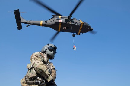 U.S. Army Garrison Humphreys 3-2 General Support Aviation Battalion HH-60m aircrew members prepare to airlift Osan Air Base personnel during hoist training at Osan AB, Republic of Korea, Nov. 12, 2020. Osan’s 51st Fighter Wing Survival, Evasion, Resistance and Escape trainers and the 3-2 GSAB partnered to test individual’s high-risk survival readiness. (U.S. Air Force photo by Senior Airman Greg Nash)