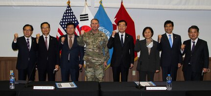 Gen. Robert B. "Abe" Abrams with several members of South Korea's National Assembly Defense Committee pose in front of flags.