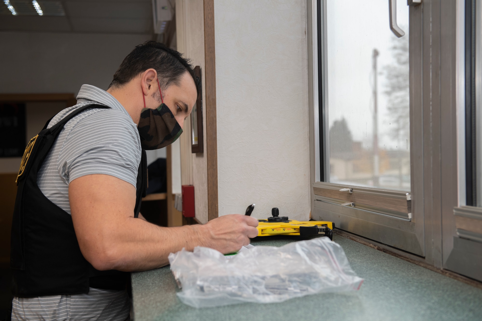 U.S. Air Force Office of Special Investigations special agent, James Godman, collects data and evidence at Spangdahlem Air Base, Germany, Nov. 16, 2020. The OSI team responded to the scene of the active shooter exercise and performed duties that would take place during the event of a real world event. (U.S. Air Force photo by Senior Airman Ali Stewart)