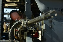 A photo of an Airman inspecting a gun.