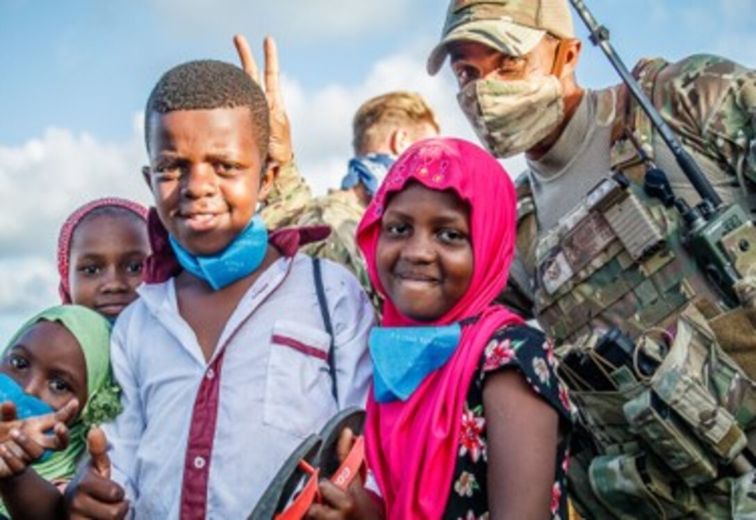 U.S. Air Force Master Sgt. Bennie Prescott, 475th Expeditionary Air Base Squadron plans and programs section chief, poses with children from Magogoni Village at Manda Bay, Kenya, Nov. 6, 2020.