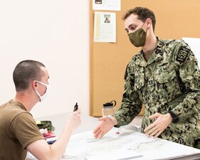 Lt. Arthur C. Morales, a class officer assigned to Officer Training Command, Newport (OTCN), Rhode Island, explains how to plot set and drift to an Officer Candidate School (OCS) student during a charting course, Nov. 13. OCS develops civilians and fleet Sailors into newly commissioned officers morally, mentally, physically and imbue them with the highest ideals of honor, courage and commitment in order to prepare graduates for service in the fleet as Naval officers. (U. S. Navy photo by Darwin Lam)