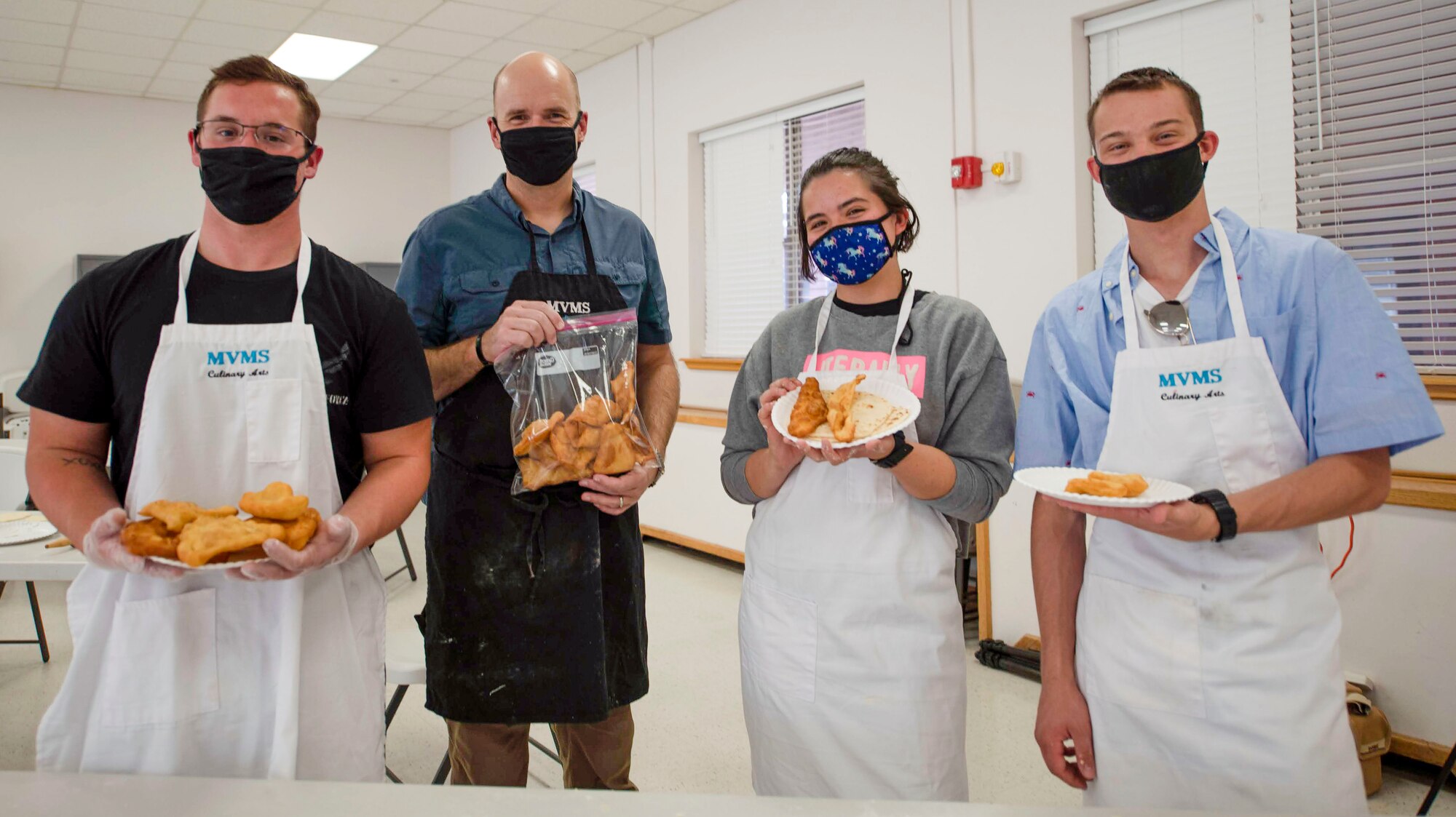 (From left to right) Airman 1st Class Hunter Breaux, 16th Training Squadron student, Col. Ryan Keeney, 49th Wing commander, Airman 1st Class Bianca Jones, 16th TRS student, and Airman 1st Class Brayden Scott, 16th TRS student, show off their homemade tortillas and sopapillas during a cooking class Nov. 7, 2020, on Holloman Air Force Base, New Mexico. The cooking class was available to Airmen and their families as part of an initiative to connect them with the culture and activities that Alamogordo has to offer.  (U.S. Air Force photo by Denise Ottaviano.)