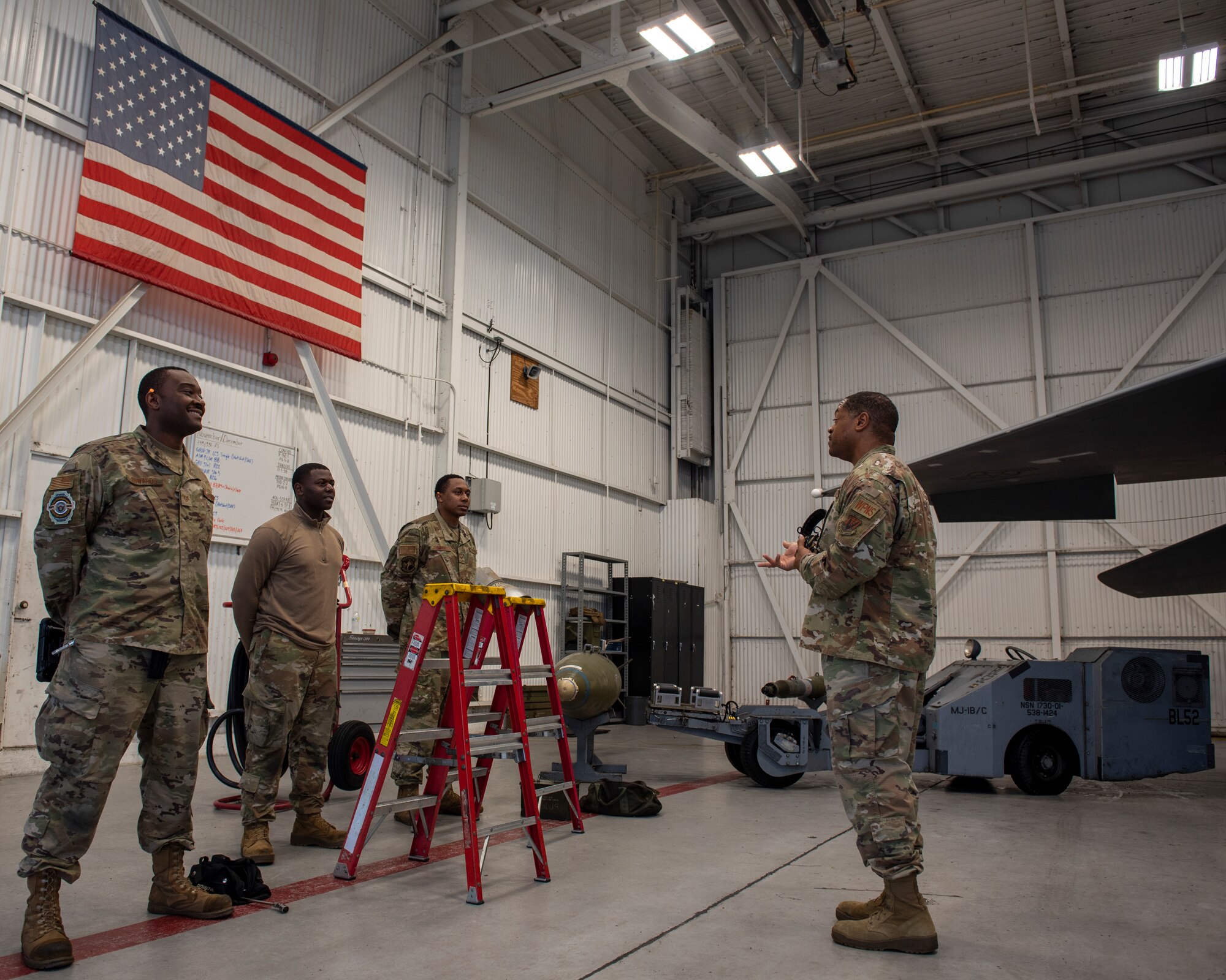 Tech Sgt. Jevon Charles, 4th Fighter Readiness Squadron weapons academic instructor (right), briefs a 3-man crew on loading a Bomb Rack Unit onto an F-15E Strike Eagle at Seymour Johnson Air Force Base, North Carolina, Nov. 12, 2020.