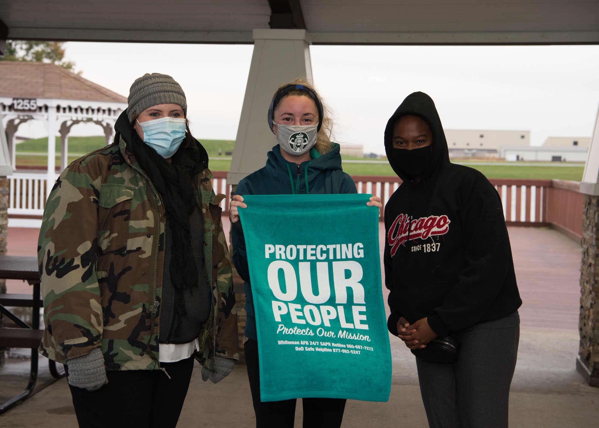 Members of Team Whiteman stand for a photo with a towel that says, "protecting our people protects our mission."