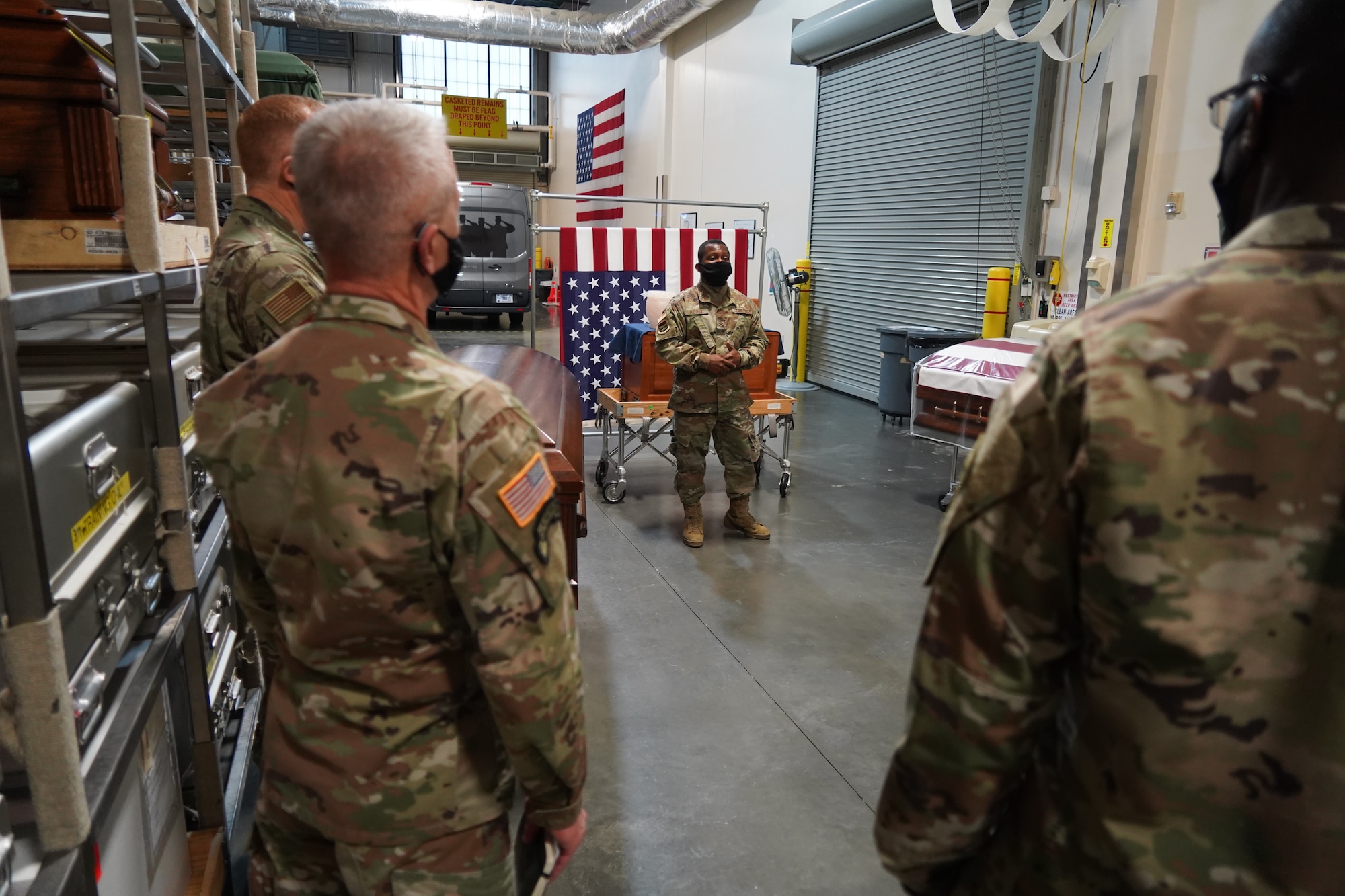 Senior Airman Carl Fleurant, Air Force Mortuary Affairs Operations departures specialist, briefs Lt. Gen. Gary Brito, Army Deputy Chief of Staff for Personnel, during a visit Nov. 13, 2020, Dover Air Force Base, Delaware. Accompanied by Chaplain (Maj. Gen.) Thomas Solhjem, Army Chief of Chaplains, and Chaplain (Brig. Gen.) William Green Jr., Deputy Chief of Chaplains, Brito was shown steps AFMAO takes to ensure each family and fallen service member is met with dignity, honor and respect. (U.S. Air Force photo by Staff Sgt. Benjamin N. Valmoja)