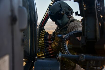 U.S. Air Force Staff Sgt. Dakota Dennis, 55th Rescue Squadron special missions aviator, reloads a gun on an HH-60G Pave Hawk II on the Coronado Islands, California, Nov. 4, 2020. The 55th RQS completed contested maritime training, to include shooting moving targets at low altitudes, to improve weapons tactics in contentious coastal areas. (U.S. Air Force photo by Airman 1st Class Kaitlyn J. Ergish)