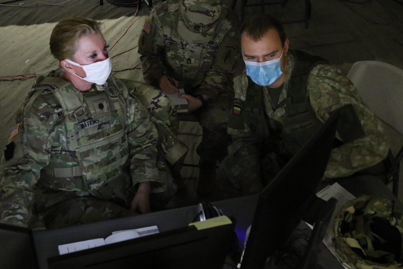 Lt. Col. Dorothy Watkins, left, a military information support operations officer, confers with OF-3 Aleksas Paulauskas, her Lithuanian Land Forces counterpart, during a two-week warfighter exercise Nov. 7, 2020, at Fort Indiantown Gap, Pennsylvania.
