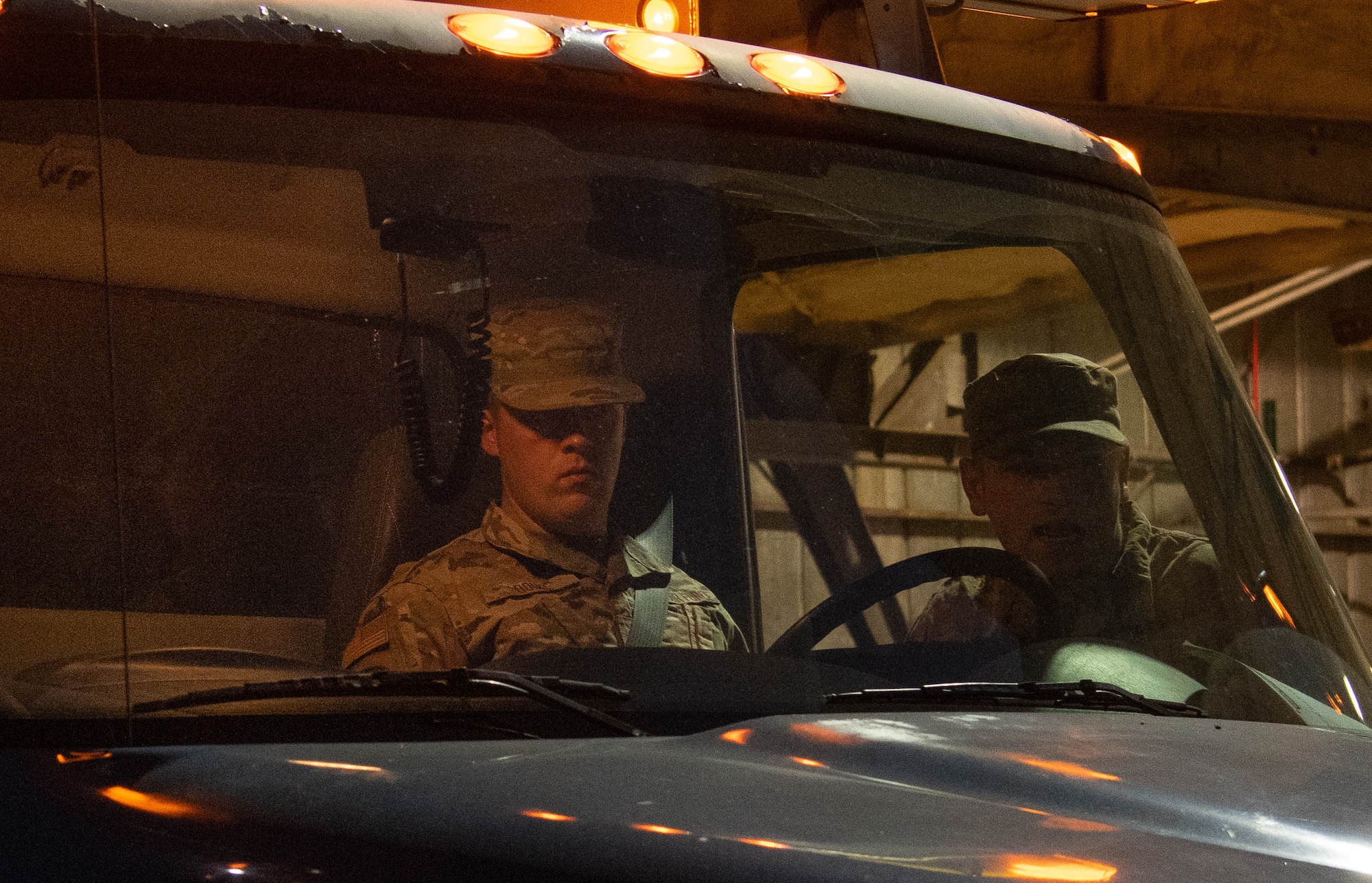 Two men talk in car at nighttime.