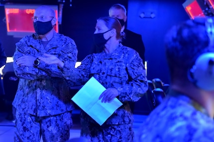 (Nov. 17, 2020) - Chief of Naval Operations (CNO) Adm. Mike Gilday speaks with Lt. Cmdr. Lisa Bydairk, the Integrated Air Missile Defense WTI Course Supervisor during a tour of the Reconfigurable Combat Information Center Trainer at the AEGIS Training and Readiness Center (ATRC) in Dahlgren, Virginia, Nov. 17. CNO traveled to Dahlgren to visit Sailors and civilians and receive briefs on a variety of programs like High Energy Lasers, Solid Laser Technology Maturation (SSL-TM) and Layered Laser Defense (LLD).  (U.S. Navy photo by Lieutenant Rachel Maul/Released)