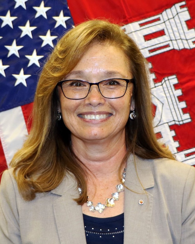 Linda Finley with the United States and U.S. Army Corps of Engineers flags behind her.