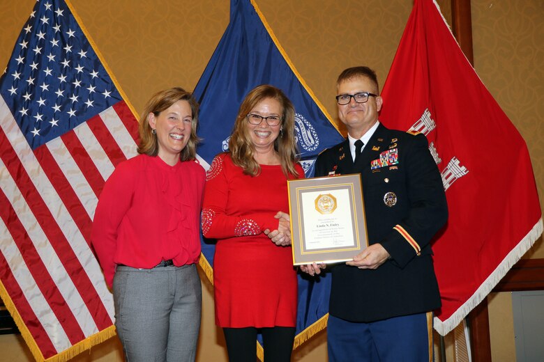 Linda Finley, center, receives her 40-year length of service award from Sacramento District Commander Col. James Handura and Tambour Eller during the 2019 holiday party awards presentation.