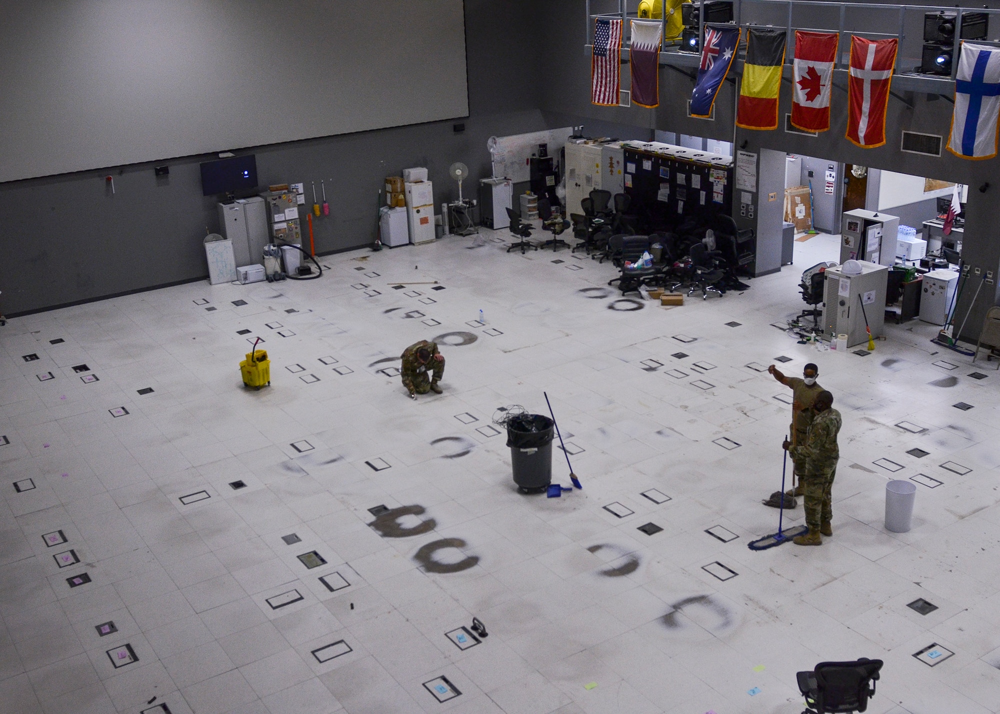 U.S. Air Forces Central Airmen from the Combined Air Operations Center, Al Udeid Air Base, Qatar, sweep and mop the newly emptied operations floor before renovations Oct. 26, 2020.