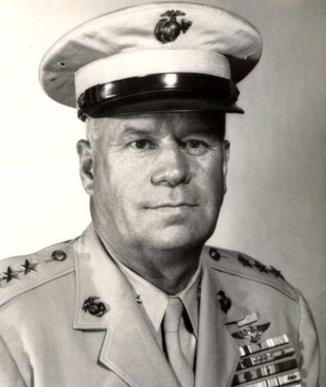 A man in uniform looks toward a camera.