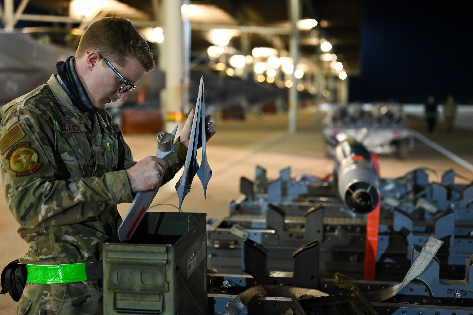 A photo of maintainers loading weapons onto and F-35A Lightning II.