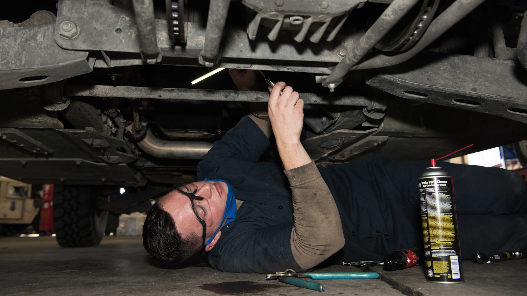 Airman 1st Class Adam Chesser, 509th Logistics Readiness Squadron vehicle maintenance technician, works on the propeller shaft on the bottom of a Humvee.