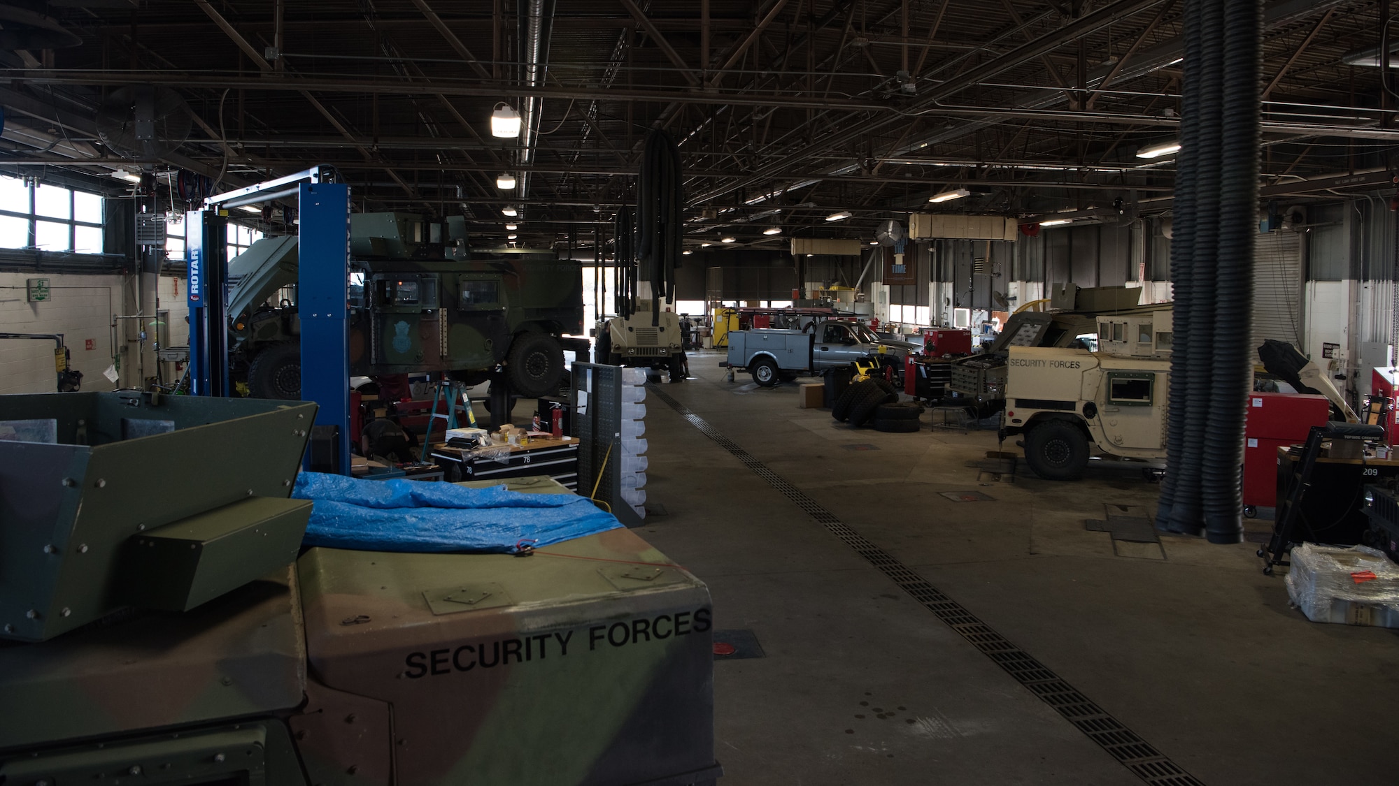 Vehicle maintenance technicians work on a variety of vehicles inside the low bay of vehicle maintenance.