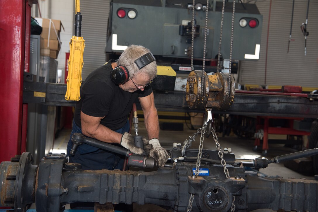 Mark Fletcher, 509th Logistics Readiness Squadron heavy mobile maintenance mechanic, takes apart an axle.