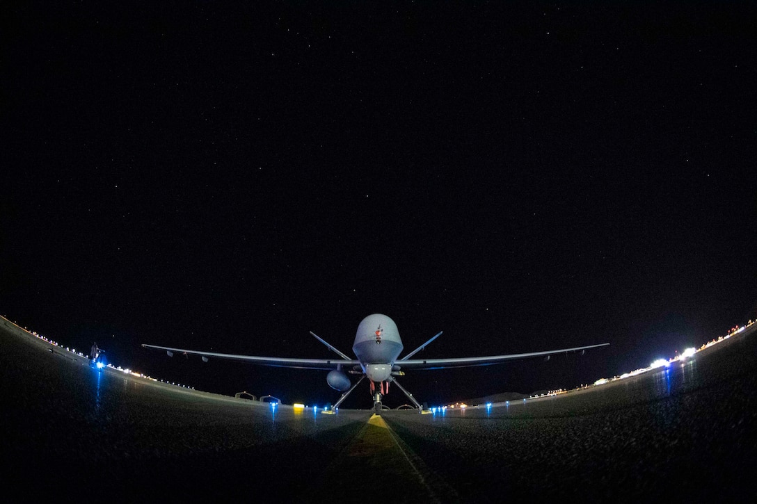 An Air Force unmanned aerial vehicle sits parked at night.
