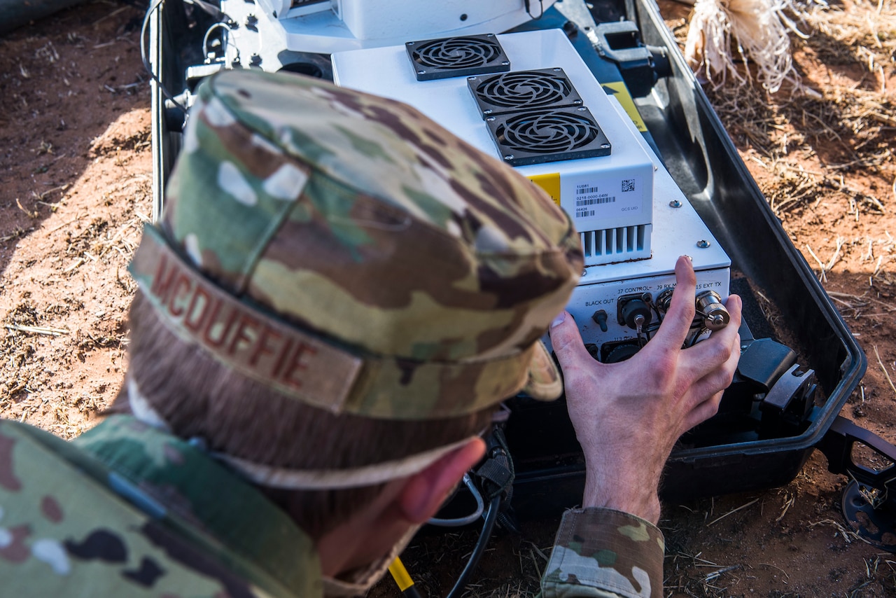 An airman works with satellite gear.