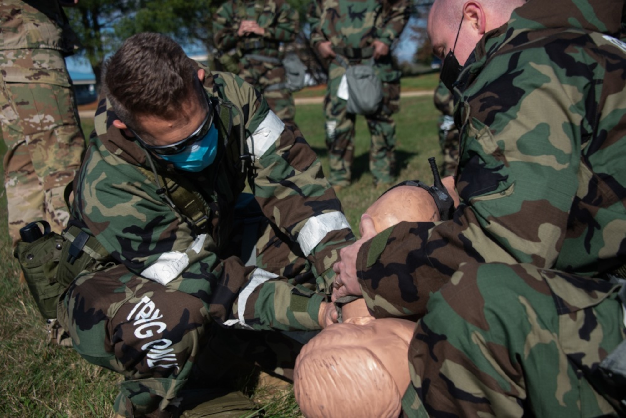 Airmen set a patient on a litter.