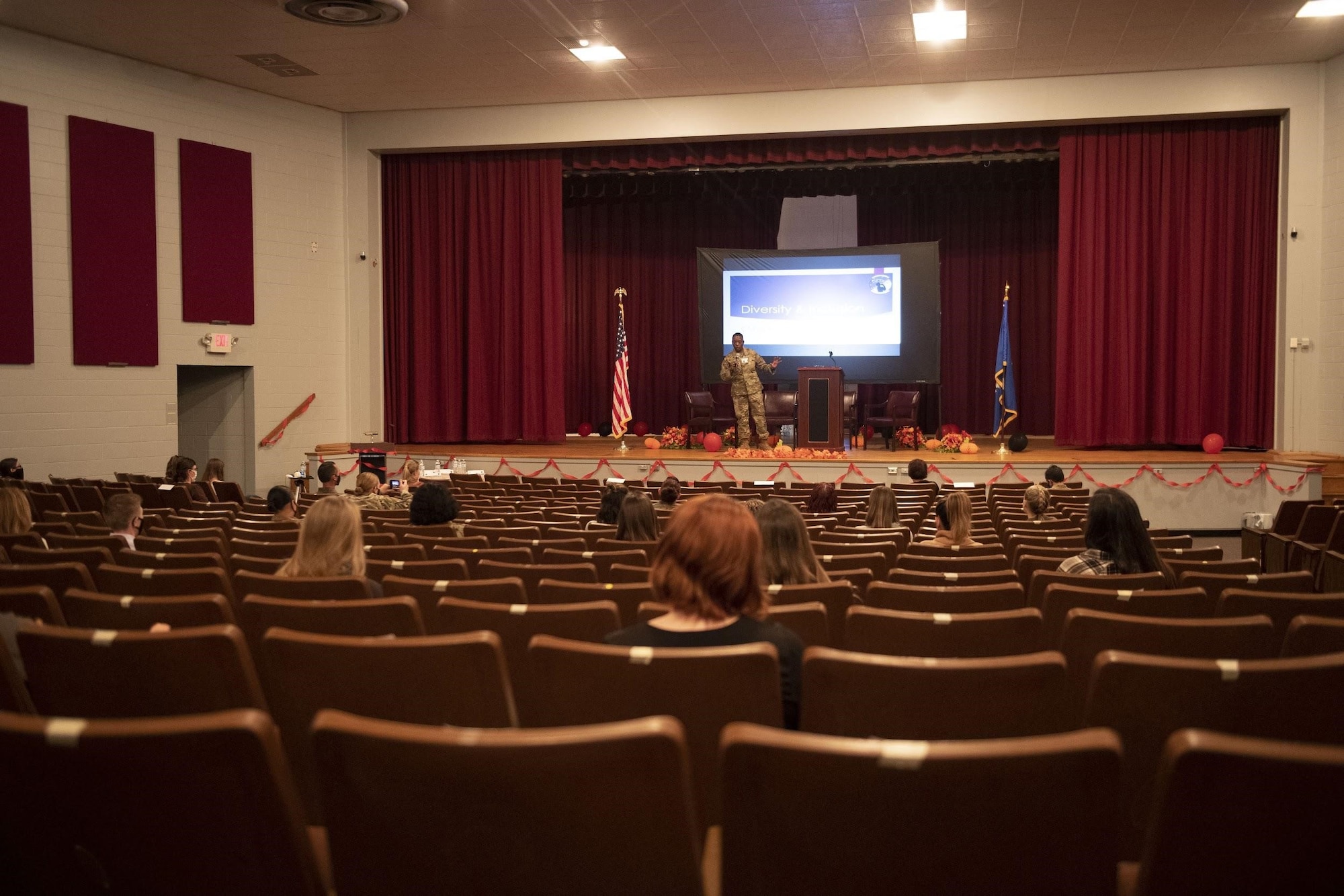 A woman stands onstage as she addresses the audience.