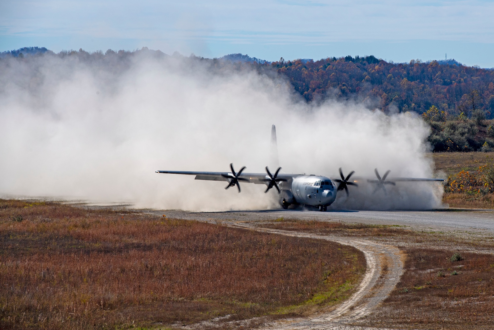 A C-130J Super Hercules lands on a dirt landing zone.