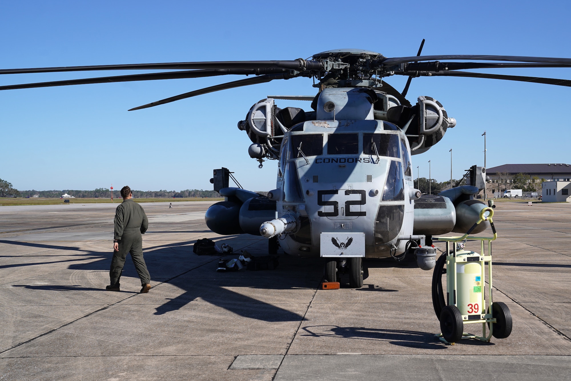 U.S. Marine Corps Sgt. Samuel Bonita, Marine Heavy Helicopter Squadron 464 aerial observer, Marine Corps Air Station New River, North Carolina, observes a Sikorsky CH-53E Super Stallion on the flightline at Keesler Air Force Base, Mississippi, Nov. 17, 2020. Marines came to Keesler to conduct routine training operations in and around the Mississippi area. (U.S. Air Force photo by Airman 1st Class Seth Haddix)