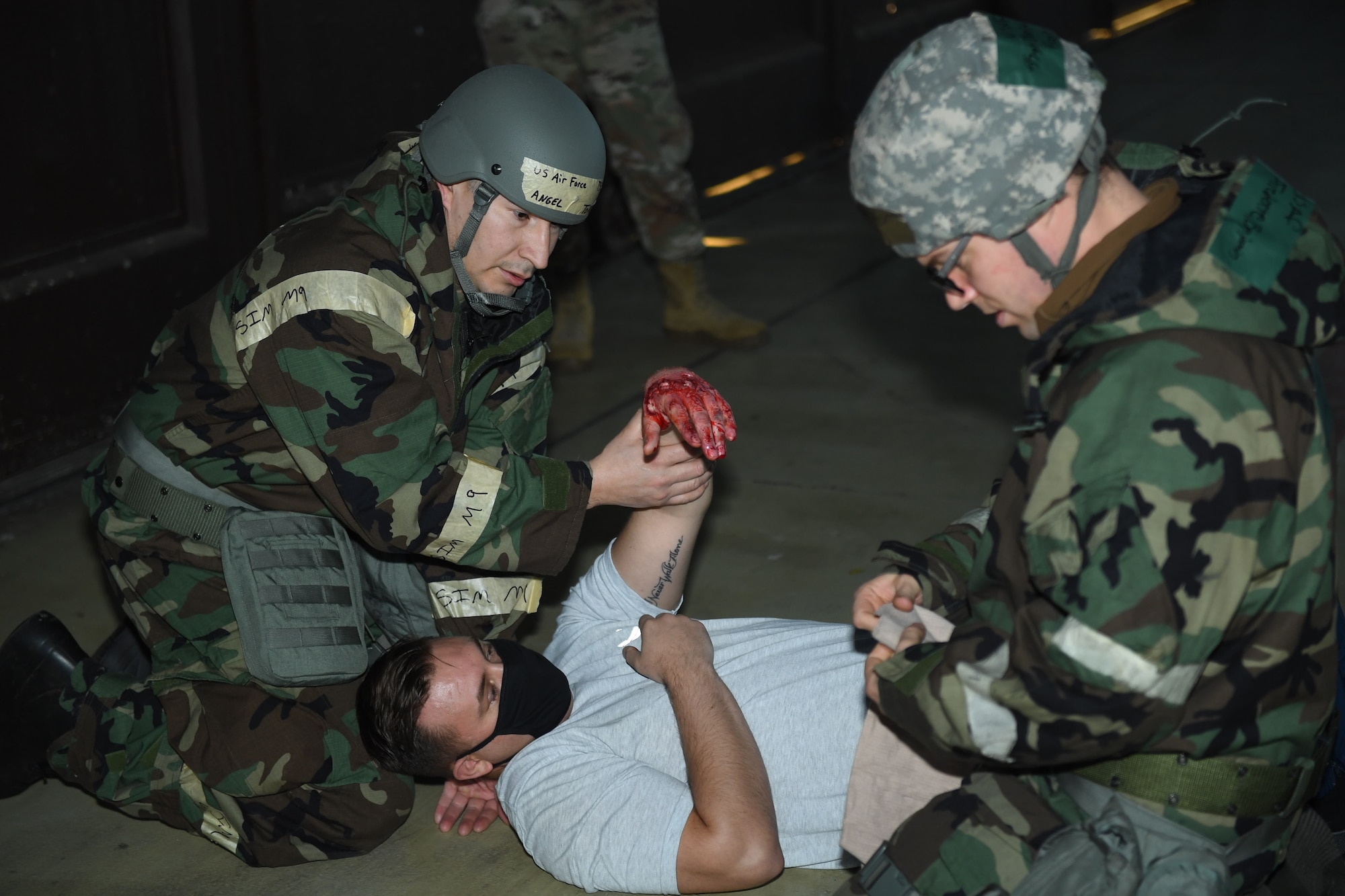 U.S. Air Force Airmen from the 52nd Maintenance Squadron tend to an Airman with a simulated injury during a base readiness exercise at Spangdahlem Air Base, Germany, Nov. 18, 2020. The simulated injury involved an Airman's hand and allowed for Wing Inspection Team members to assess Self Aid and Buddy Care procedures. (U.S. Air Force photo by Senior Airman Ali Stewart)