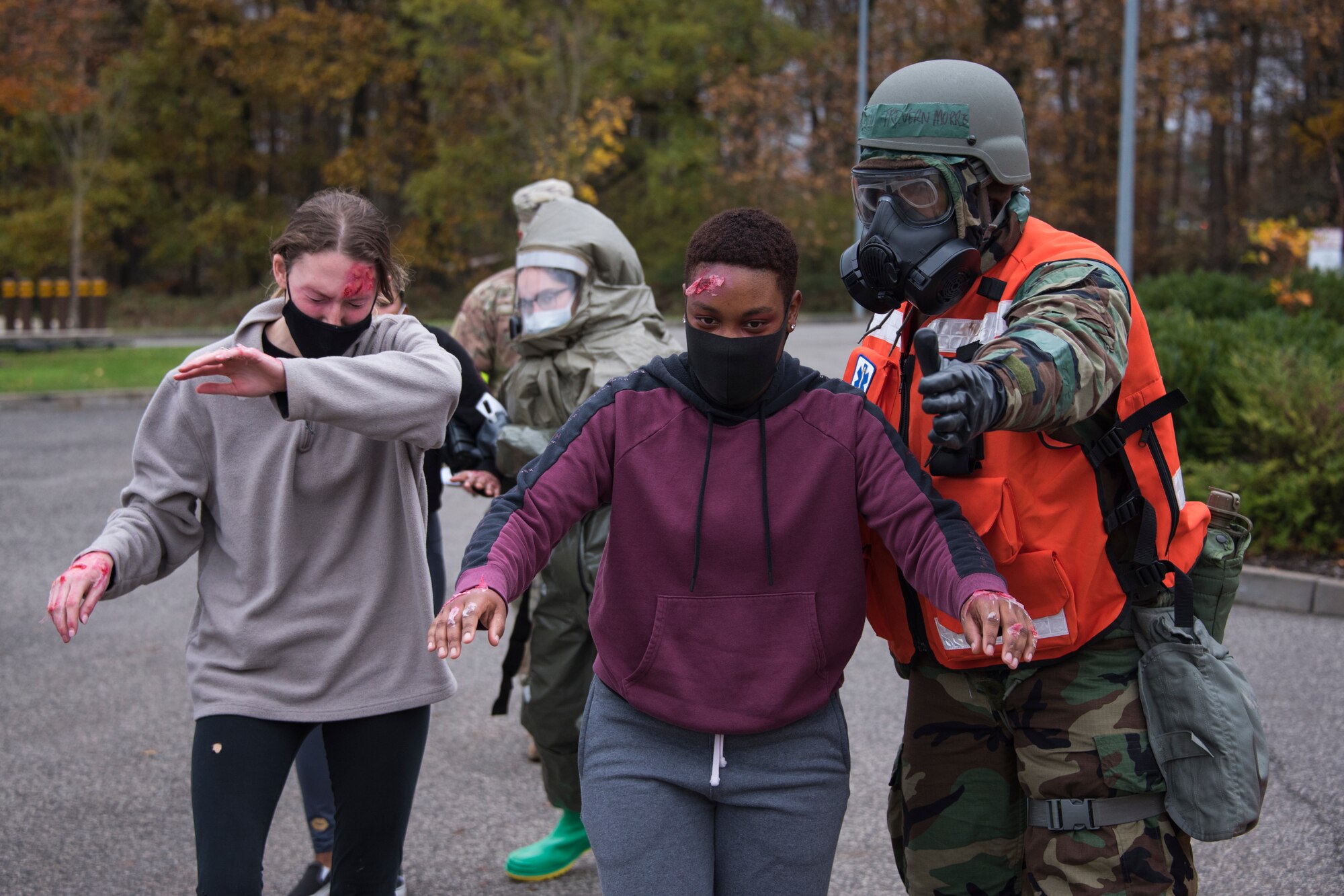 An Airman assisting with initial triage, right, directs mock victims to an in-place patient decontamination tent during an exercise at Spangdahlem Air Base, Germany, Nov. 17, 2020. Simulated victims with possible exposure to an airborne substance must go through the IPPD process before being allowed admittance to the hospital. (U.S. Air Force photo by Senior Airman Chance D. Nardone)