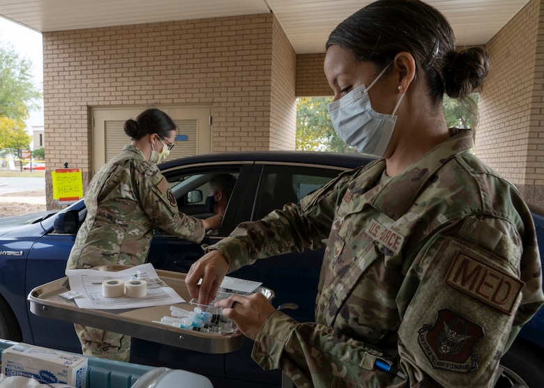 Photo of Airmen preparing and administering flu shots.