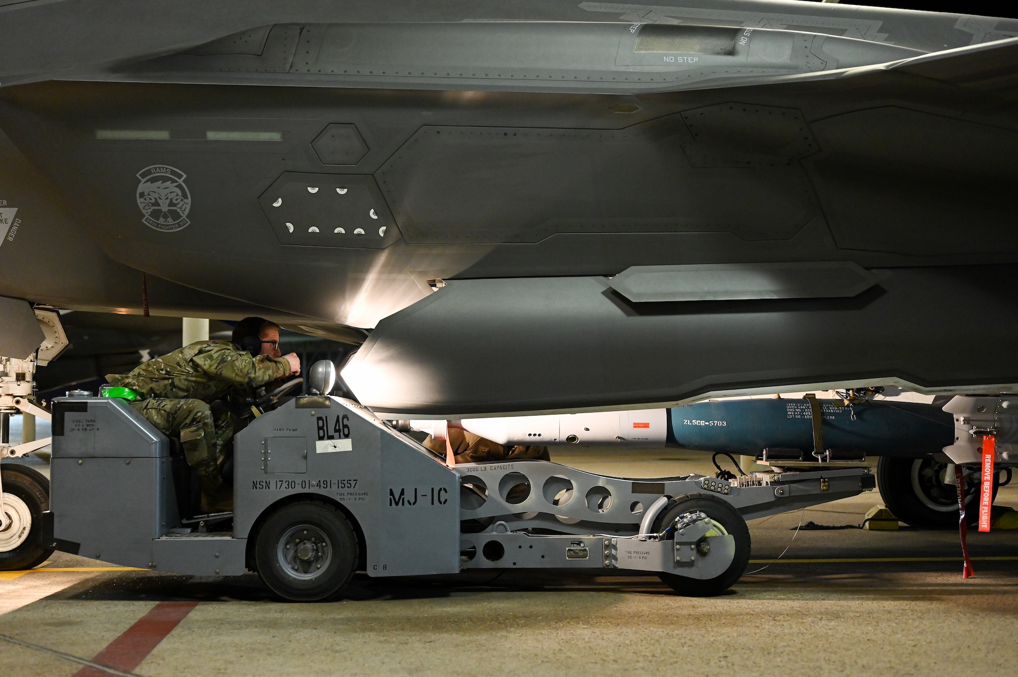 A photo of maintainers loading weapons onto and F-35A Lightning II.