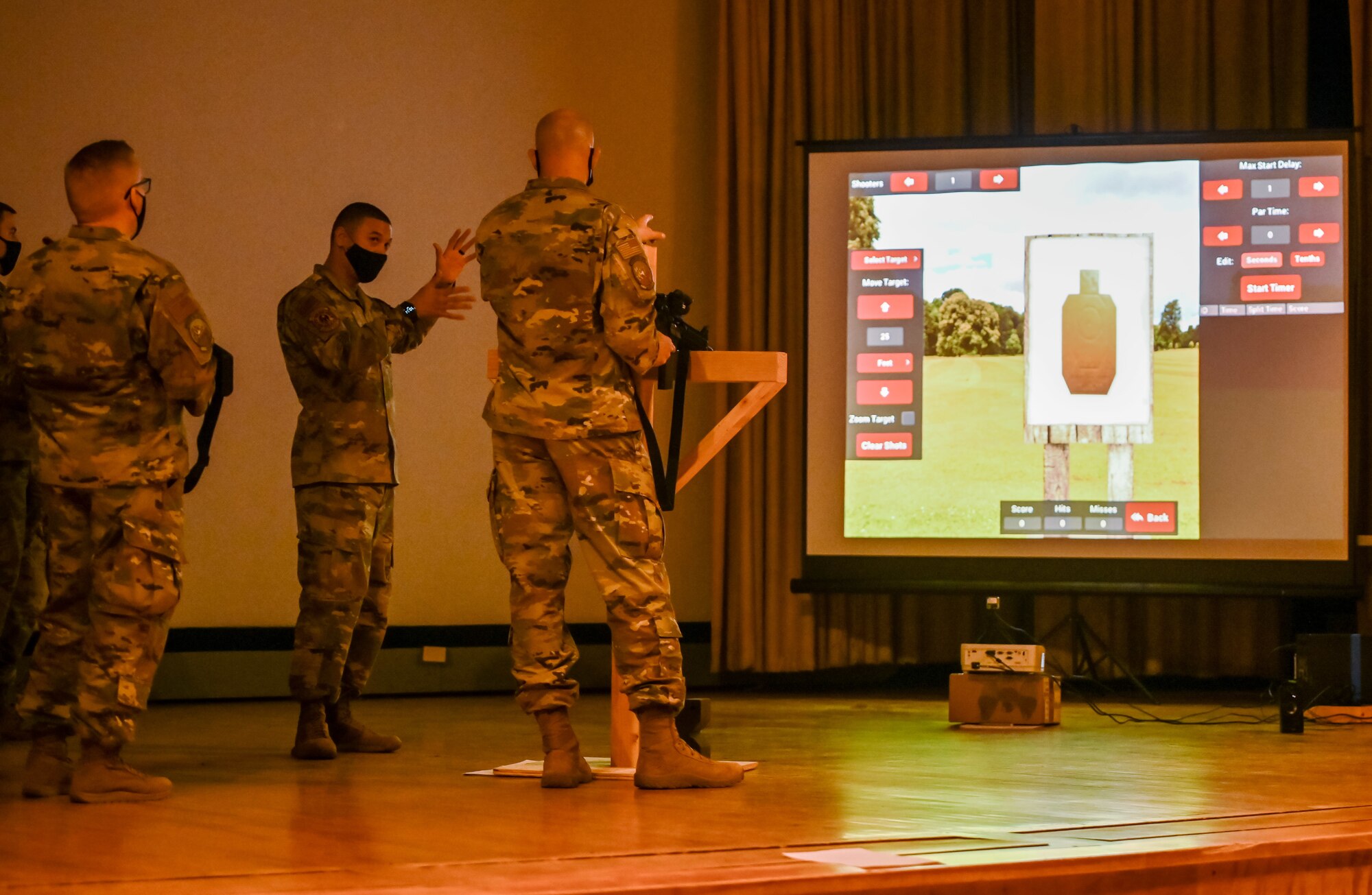 Technical Sgt. Israel Navarro (middle), 729th Air Control Squadron, demonstrates a laser-based, dry fire weapons training system Nov. 6, 2020, at Hill Air Force Base, Utah for Chief Master Sgt. Aron Garrard (right), 388th Maintenance Squadron, Nov. 6, 2020 at Hill Air Force Base, Utah. Airmen in 729th ACS are using the system for training to help them weapons qualify before deployments.  (U.S. Air Force photo by Cynthia Griggs)