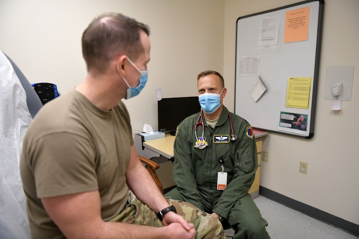 Photo shows doctor talking with patient.