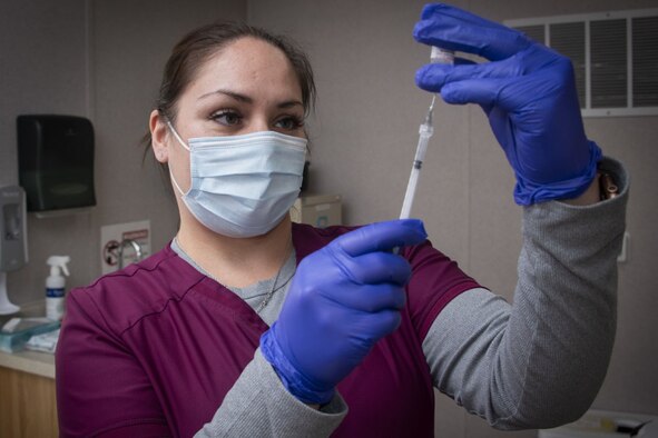 A pharmacy technician prepares an injection.