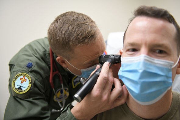 Photo shows doctor looking in patient's ear.