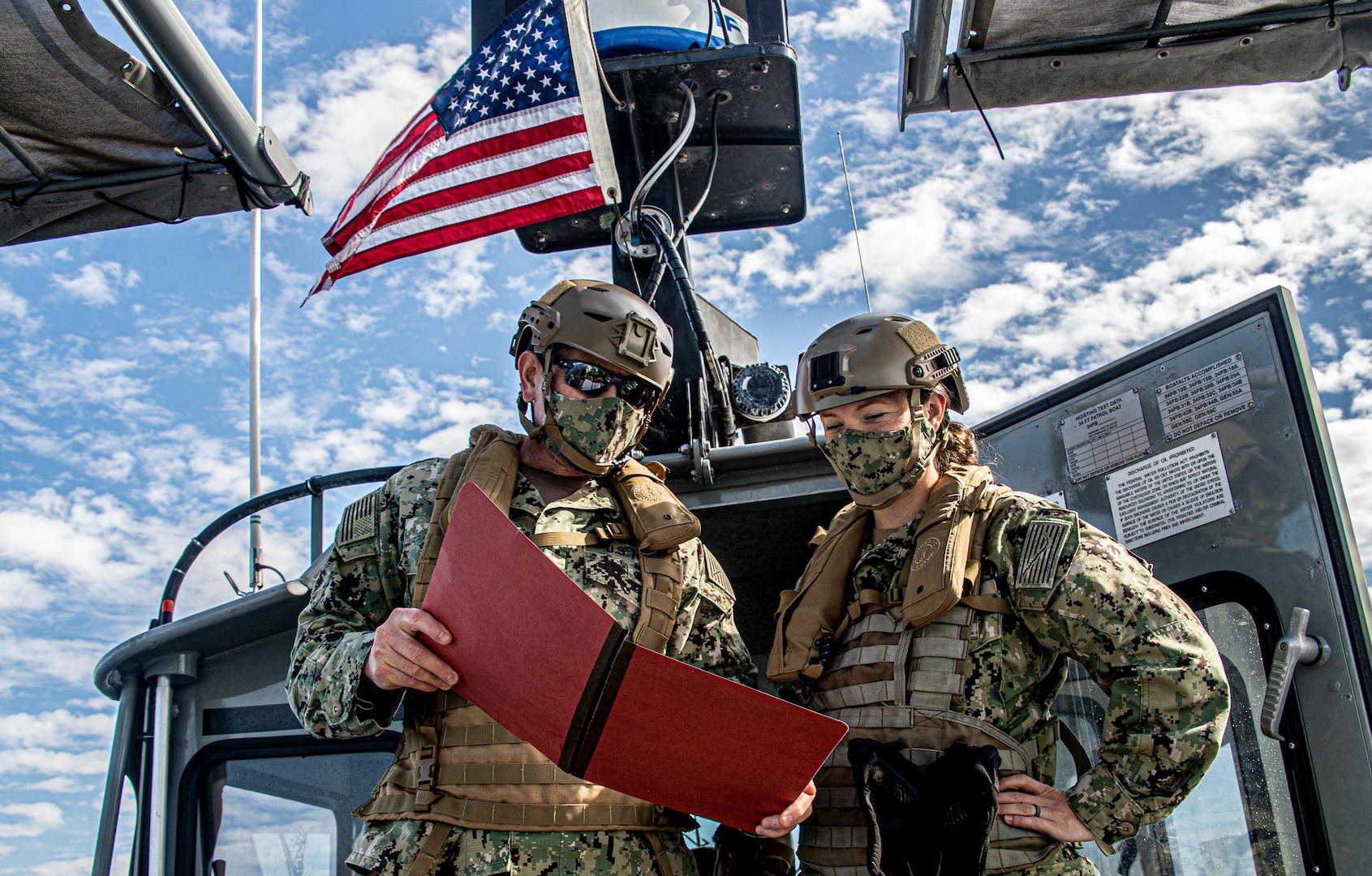 Training officer, on left, assigned to Maritime Expeditionary Security Squadron 11, briefs squadron’s chief staff officer and executive officer aboard 34-foot Sea Ark patrol boat during navigation check ride exercise off coast of Long Beach, California, November 12, 2020 (U.S. Navy/Nelson Doromal, Jr.)