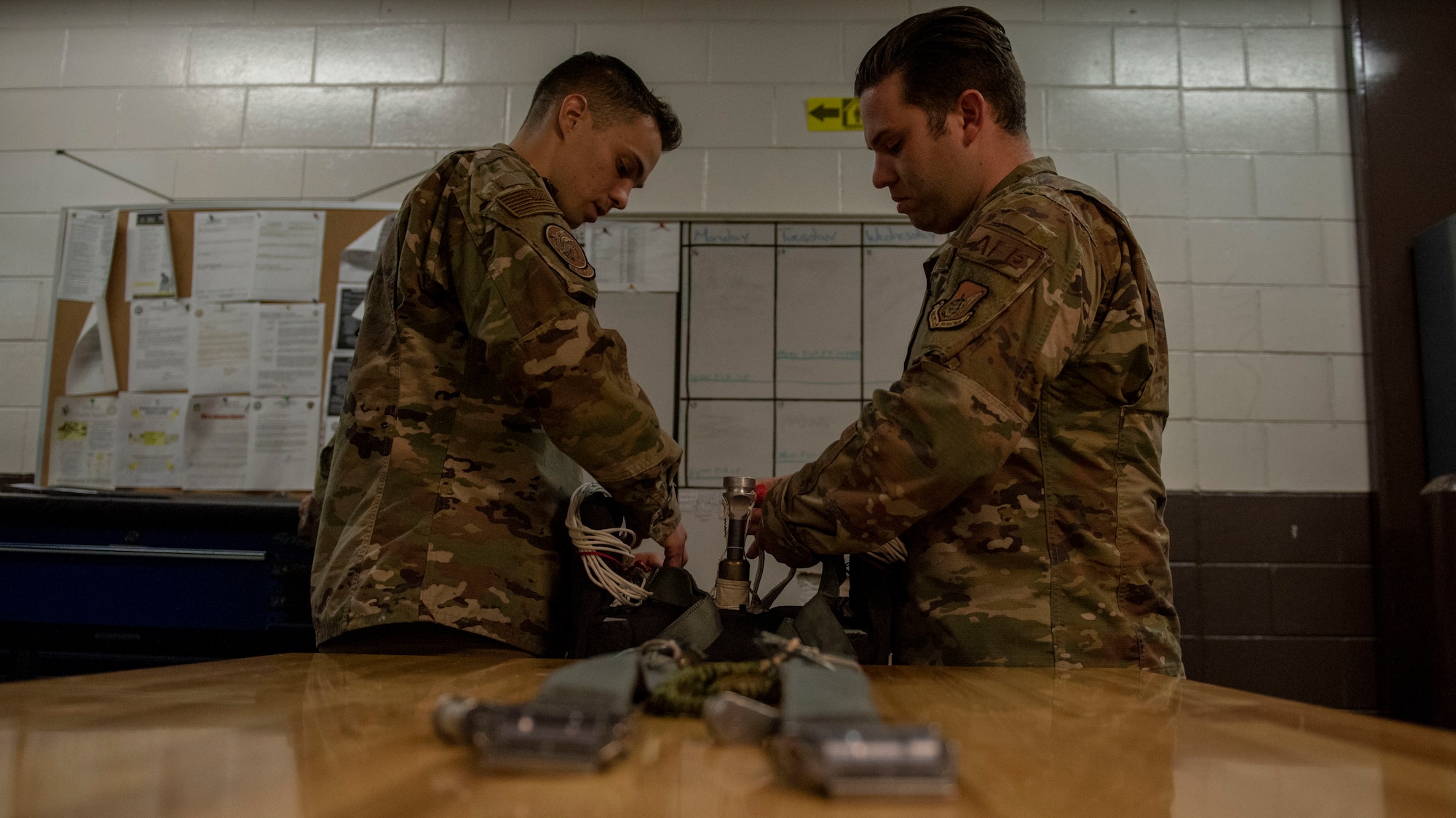 Two Airmen pack a parachute