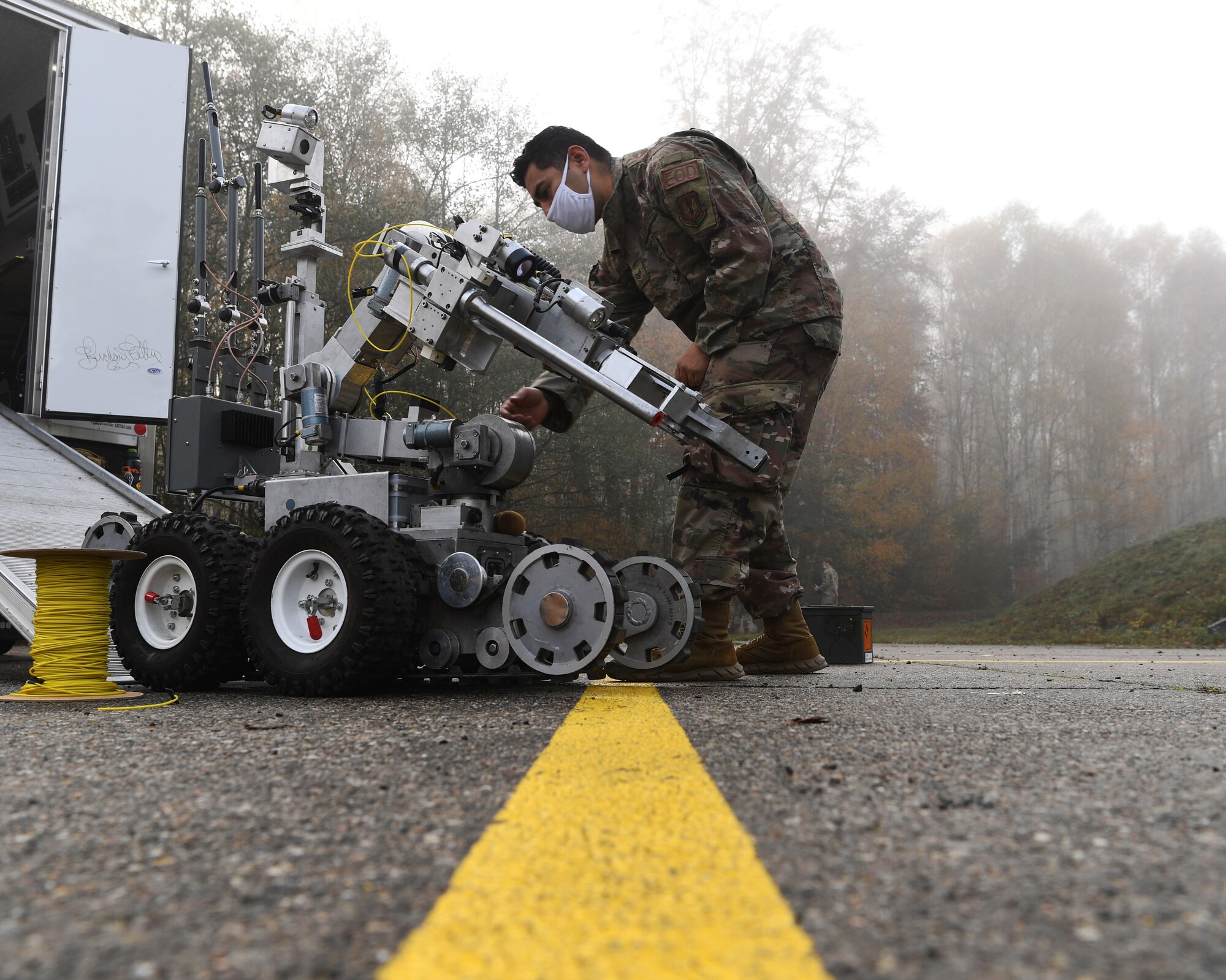 man adjusts robot