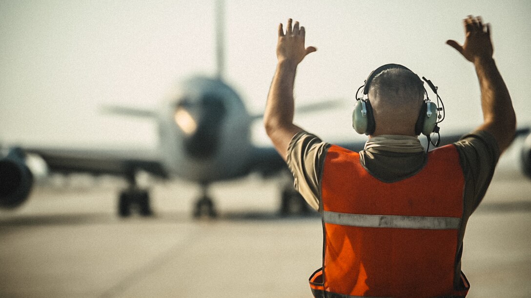 U.S. Air Force Tech. Sgt. Darren Ricchiazzi, crew chief for the 379th Expeditionary Aircraft Maintenance Squadron, marshalls out a KC-135 Stratotanker at Al Udeid Air Base, Qatar, Nov. 18, 2020. The aircraft launched immediately after hot refuel training during which maintenance crews safely refueled the aircraft while the engines remained running. This capability allows the KC-135 to rapidly redeploy and carry on the mission of continuous aerial refueling across the globe. (U.S. Air National Guard photo by Staff Sgt. Jordan Martin)
