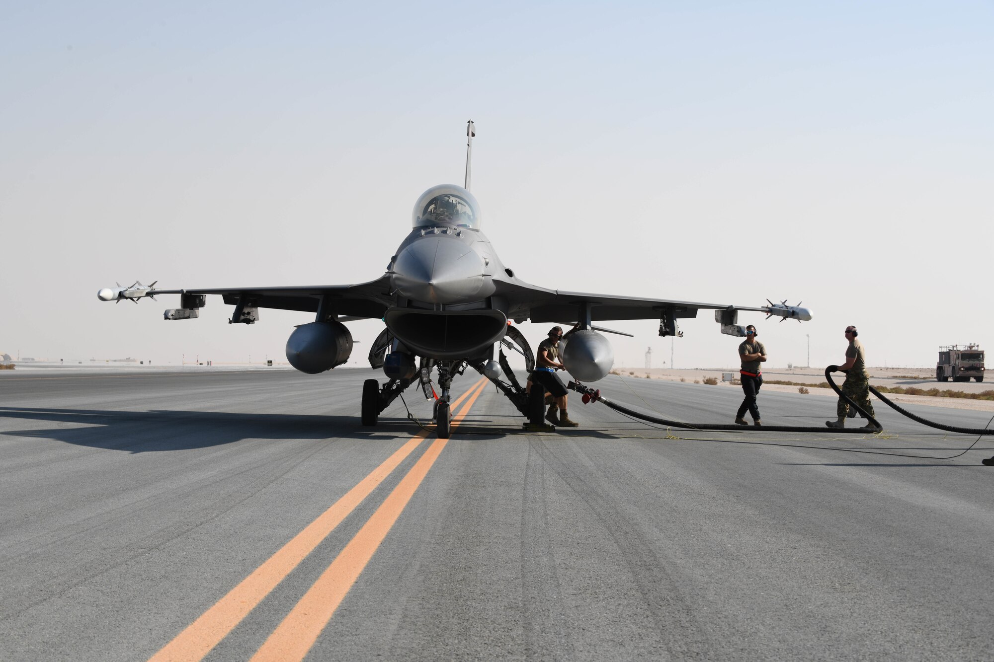 Airmen assigned to the 379th Expeditionary Maintenance Group at Al Udeid Air Base, Qatar, hook a fuel hose to a U.S. Air Force F-16 Fighting Falcon assigned to the 77th Fighter Squadron from Prince Sultan Air Base, Kingdom of Saudi Arabia, on the flight line of AUAB on Nov. 10, 2020. The training qualified AUAB Airmen assigned to the 379th Expeditionary Maintenance Group and the 379th Expeditionary Logistics Readiness Squadron to support 24-hour hot refueling operations on multiple aircraft that rotate through the base. Hot refueling allows aircrew to land and keep their engines running while they refuel, before taking off to continue the next leg of their respective missions. (U.S. Air Force photo by Staff Sgt. Kayla White)
