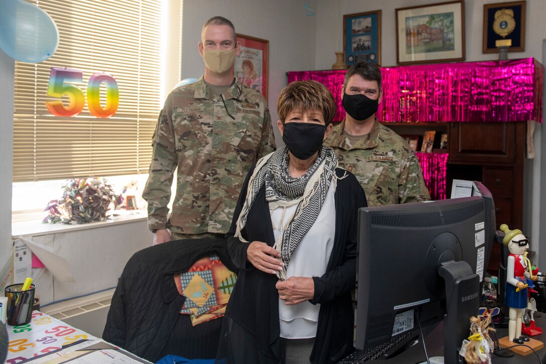 Two Airmen stand with civilian woman.