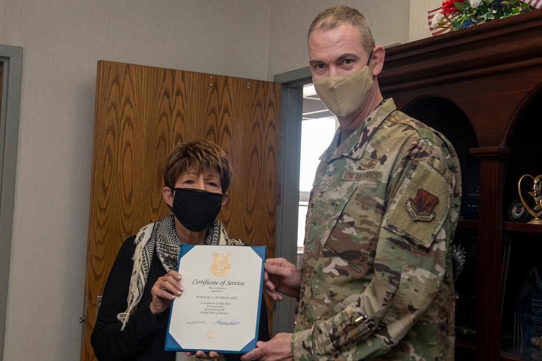 Woman and Airman hold a certificate.