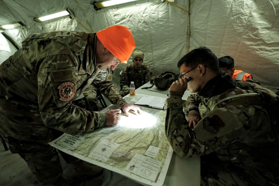 Airmen in the 729th Air Control Squadron study a topographic map.