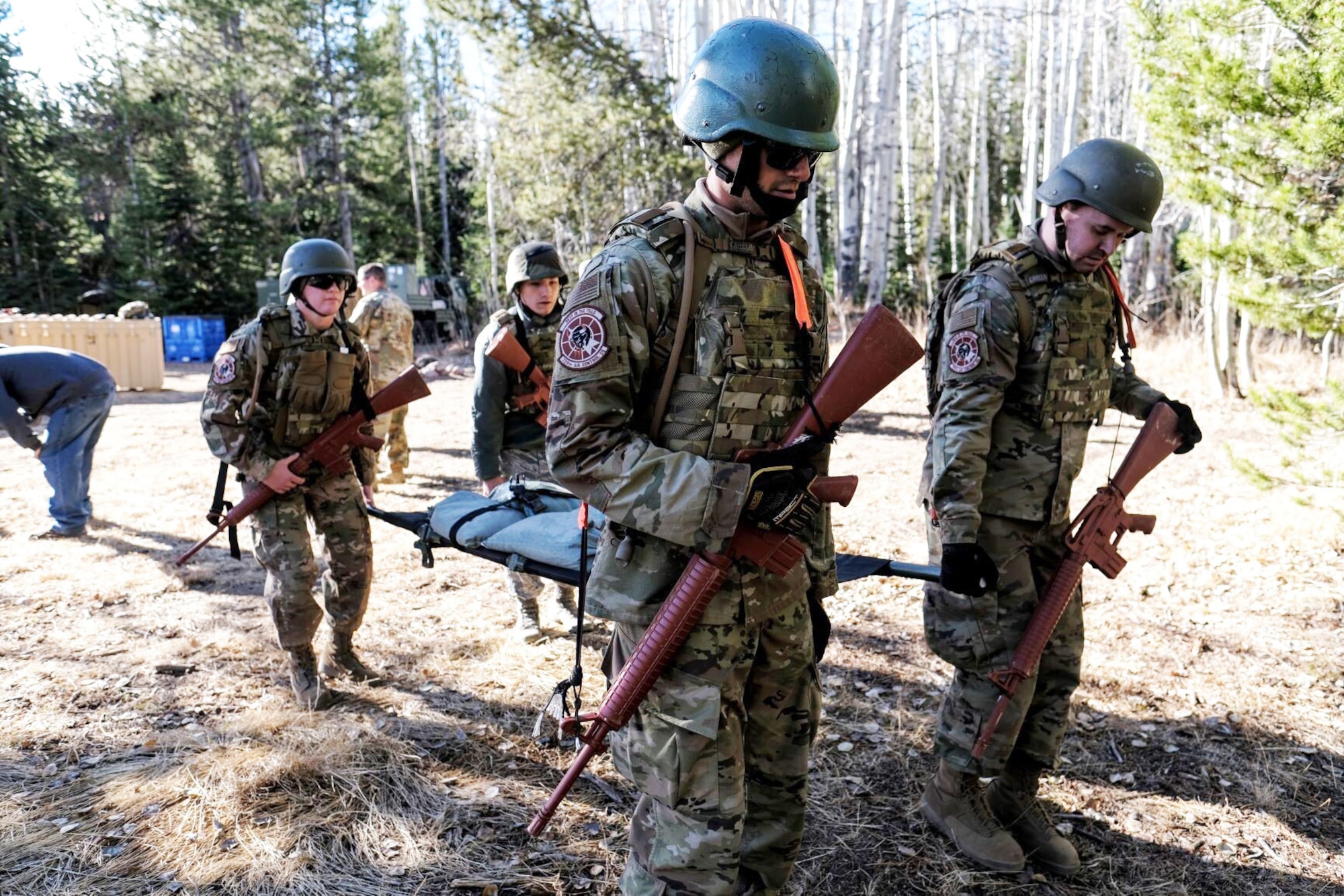 Airmen in the 729th Air Control Squadron practice self-aid and buddy care by carrying a simulated injured patient on a stretcher.