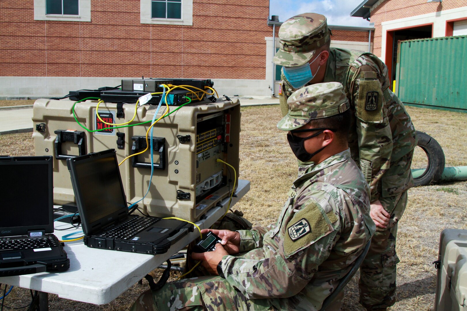 Spc. Martin Galvan, 62nd Expeditionary Signal Battalion multichannel transmission systems operator maintainer, runs a communications check, while Pfc. Nathaniel Davis, 62nd Expeditionary Signal Battalion multichannel transmission systems operator maintainer, observes during the Urban Search and Rescue lane at the San Antonio Fire Academy Nov. 6. This exercise helps assure readiness by ensuring units are interoperable and able to function as part of a cohesive national response.